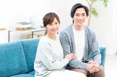 ソファに並んで微笑む夫婦