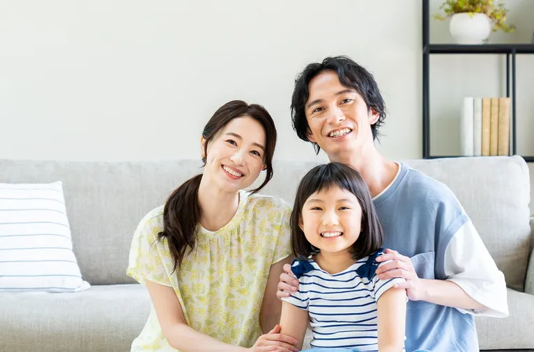 リビングで笑顔の3人家族