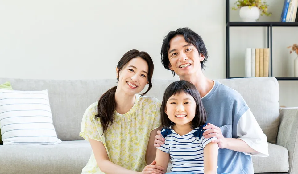 リビングで笑顔の3人家族
